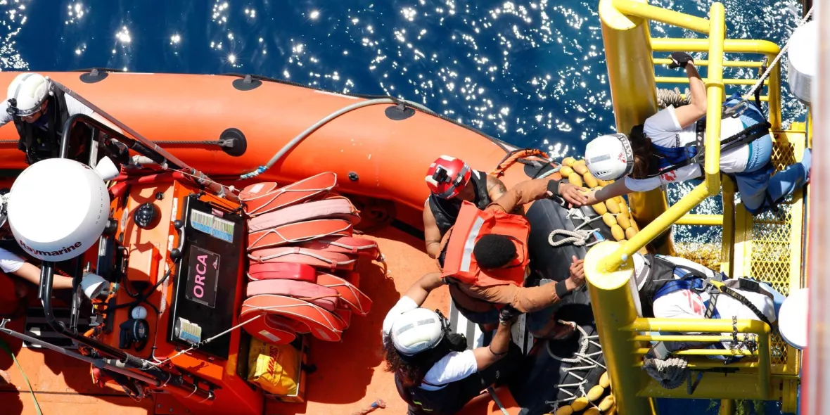 Eine gerettete Person klettert an Bord der Geo Barents