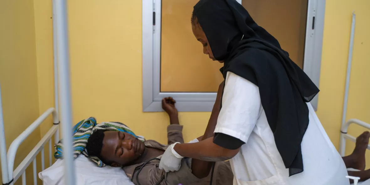 Krankenschwester mit Stethoskop an Patientenbett