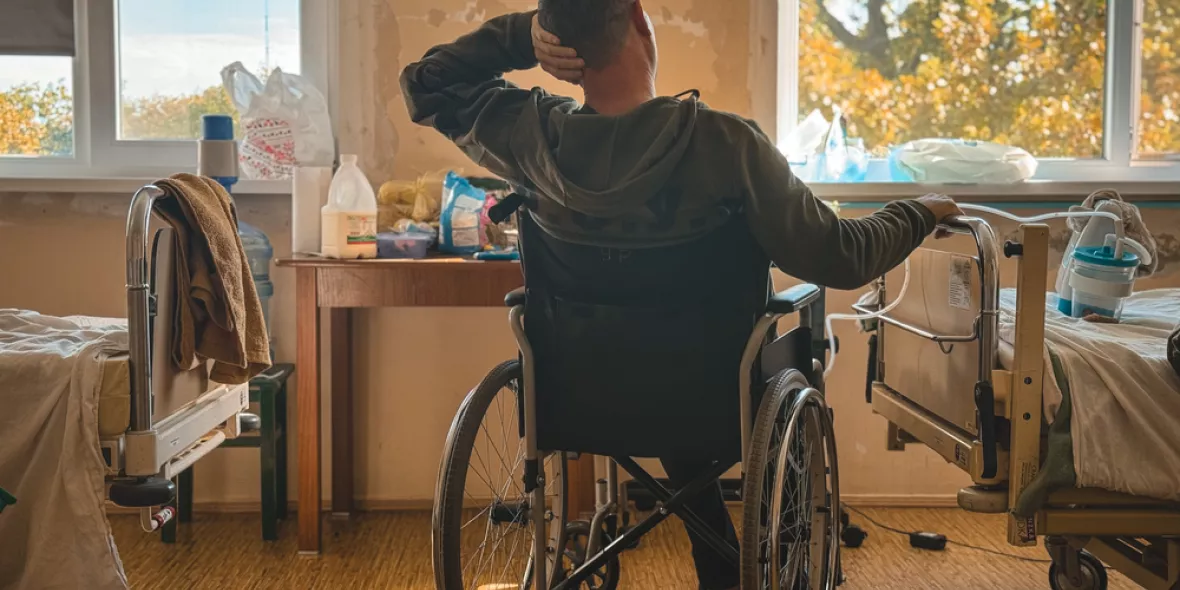 Patient sitzt im Rollstuhl in einem Krankenhauszimmer