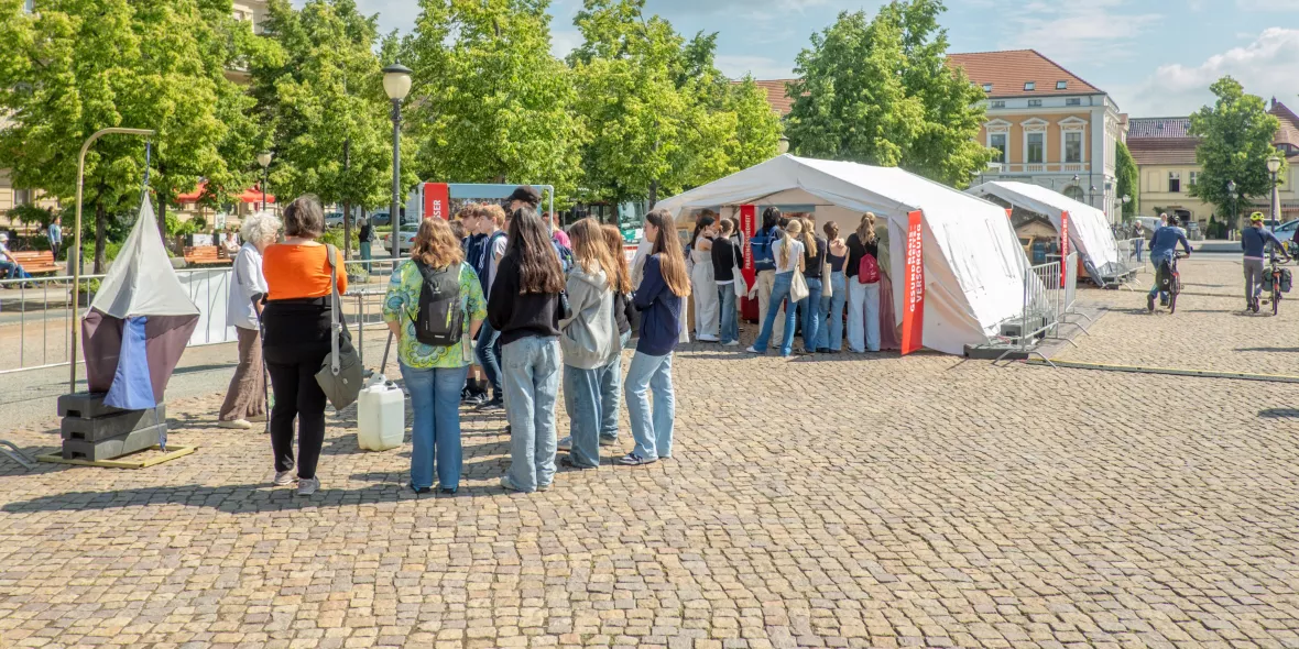 Menschenansammlung vor Zelten der Freiluftausstellung