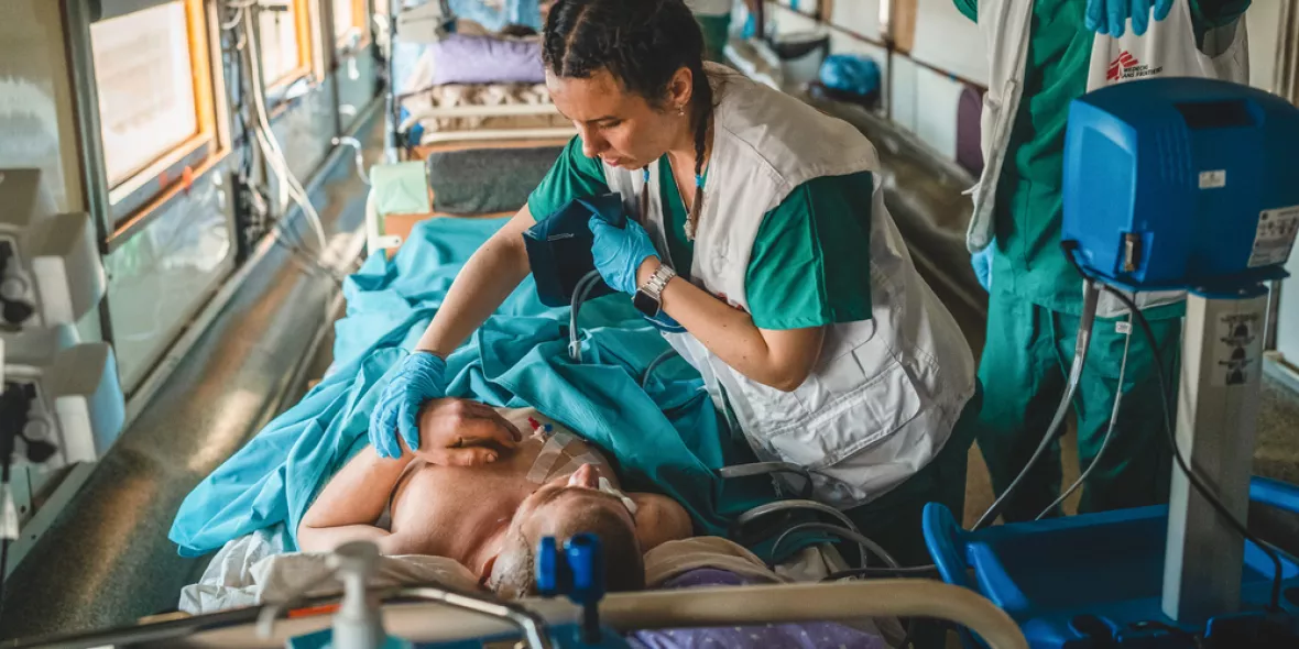 Zwei Mitarbeitende arbeiten an Bett von Patient in Zug