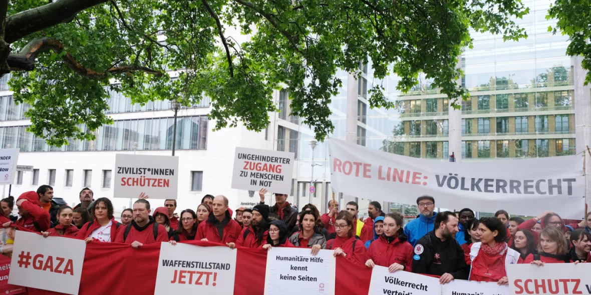 Menschen mit Plakaten demonstrieren vor Auswärtigem Amt