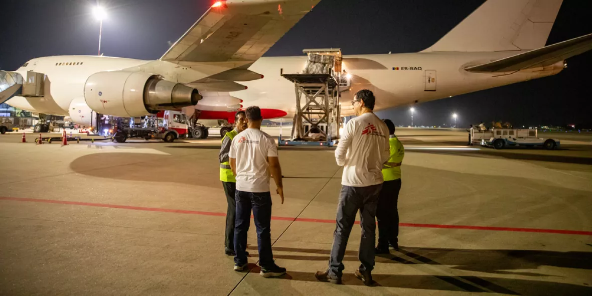 Zwei Menschen vor einem Flugzeug mit Hilfsgütern
