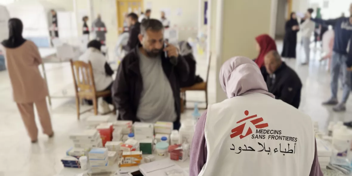 Eine Mitarbeiterin gibt Medikamente an Patient*innen aus.