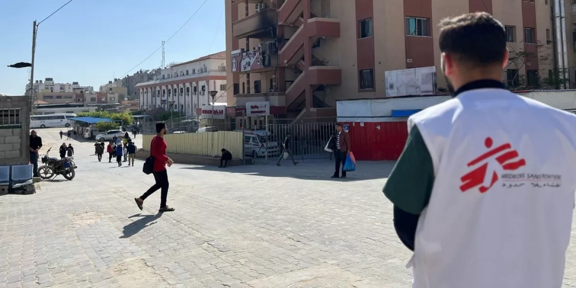 Einer unser Mitarbeitenden steht vor dem Nasser-Krankenhaus