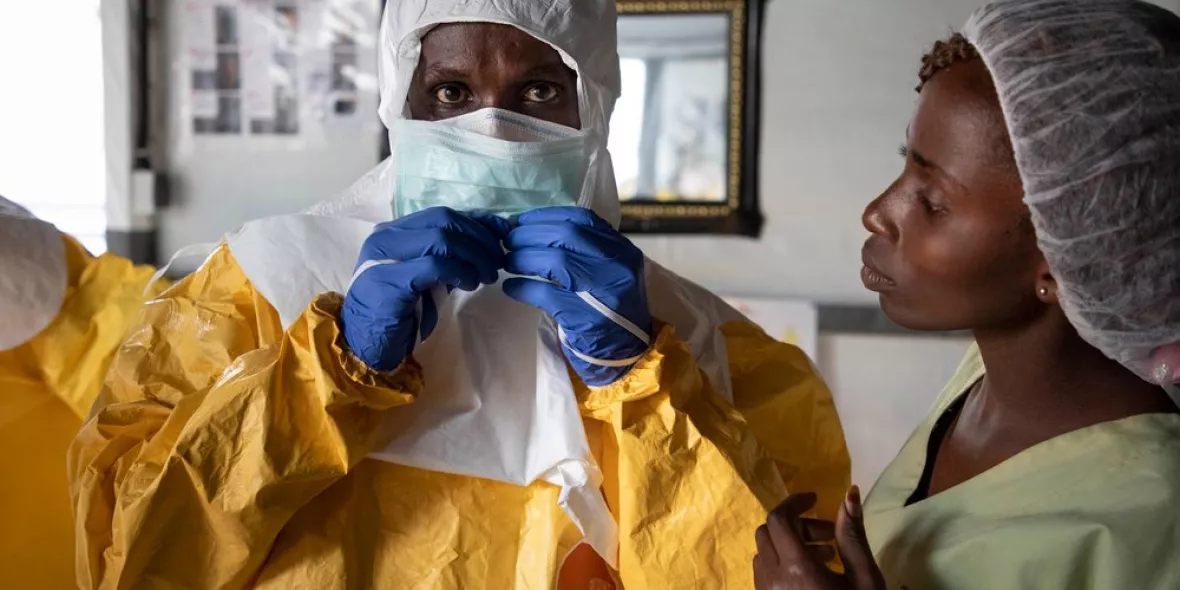 Mitarbeiter in Schutzausrüstung vor Ebola-Transitzentrum