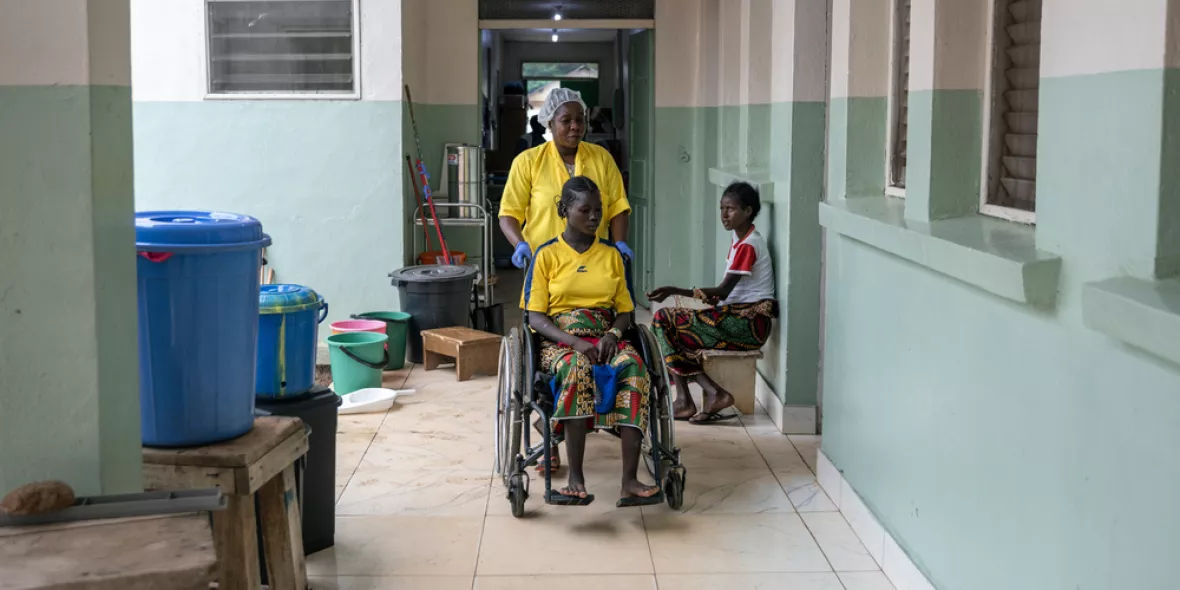 Zwei Patientinnen und eine Mitarbeitende in Wartebereich