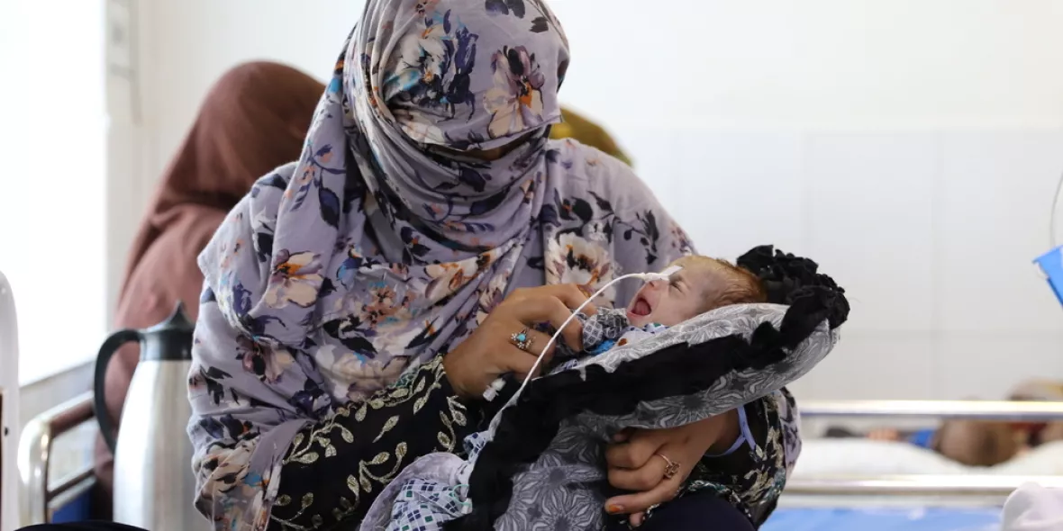 Eine Frau hält ein kleines Baby im Arm.