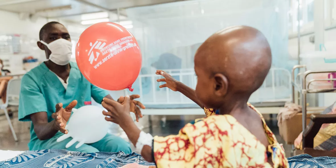 Pfleger bringt kleinen Patientin einen Luftballon