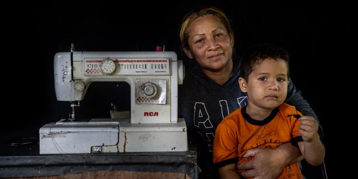 Eine Venezolanerin mit ihrem Sohn und einer Nähmaschine