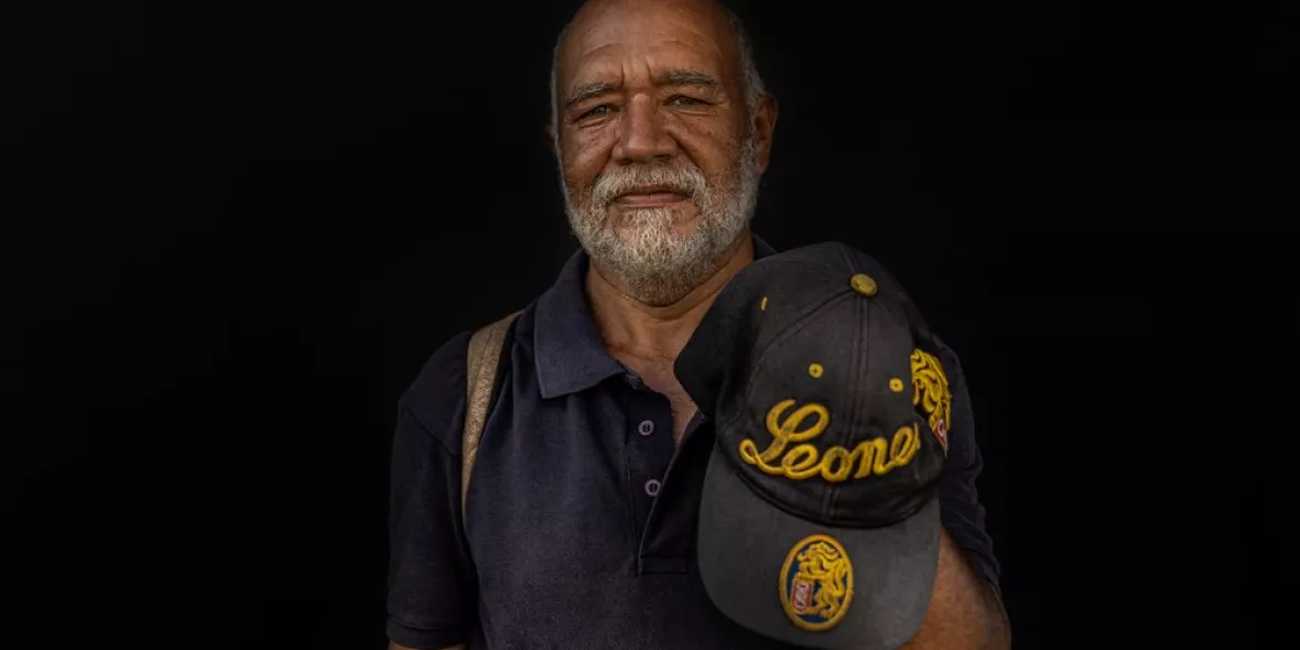 Ein Venezolaner mit einer Baseballmütze in der Hand