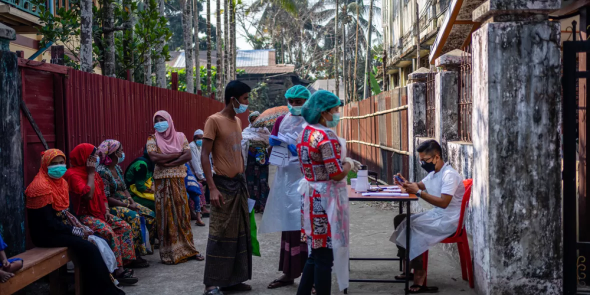 Patient*innen stehen am Eingang der mobilen Klinik in Aung Mingalar, Sittwe
