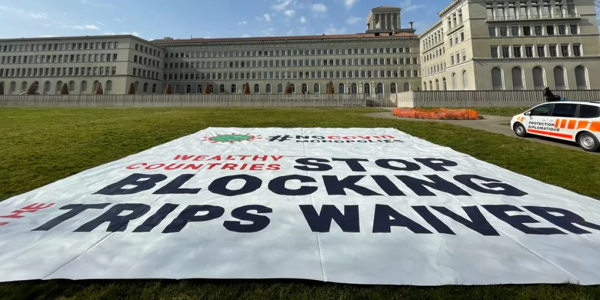 Das Gebäude der WTO und das Plakat zum TRIPS-Waiver