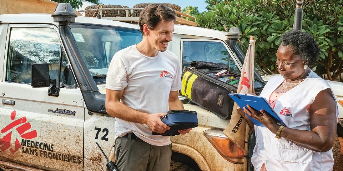Zwei Mitarbeiter*innen kontollieren die Materialien für die mobile Klinik