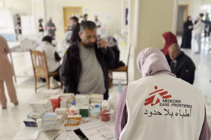 Eine Mitarbeiterin gibt Medikamente an Patient*innen aus.