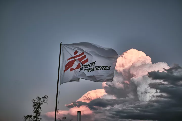 Flagge mit Logo von Ärzte ohne Grenzen vor bewölktem Himmel