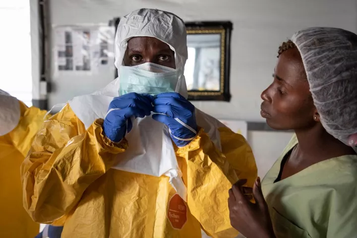 Mitarbeiter in Schutzausrüstung vor Ebola-Transitzentrum