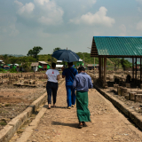 Myanmar: Mitarbeitende laufen über abgebrannten Marktplatz