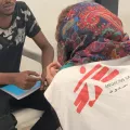 Arzt spricht mit Flüchtling in libyschem Internierungslager