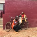 Der 8-jährige Dieu-Beni und sein Vater auf einem Fahrrad.