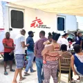 Migranten warten vor einer mobilen Klinik