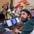 Menschen vor Computern sitzend schauen alle in eine Richtung.