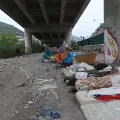 Provisorische Unterkunft aus Betten und Zelten unter einer Brücke
