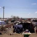 Ein Camp aus provisorischen Zeltunterkünften mit Menschen