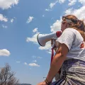 Eine Person von hinten in Ärzte ohne Grenzen Shirt mit Megaphone