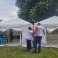 Zwei Mitarbeitende vor einem Zelt, in dem Cholera behandelt wird.