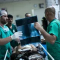 Chirurgen besprechen Röntgenbild mit Patient - humanitäre Arbeit