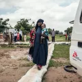 Frau trägt Töchter auf Arm