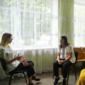 Drei Frauen in Stuhlkreis im Gespräch miteinander, eine ist Projektkoordinatorin
