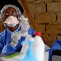 Eine Person in Schutzkleidung bereitet eine Ebola-Impfung vor.