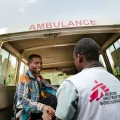 Ein Mitarbeiter hilft einem Patienten an Bord eines Krankenwagens