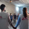 Irak: Mitarbeitende und Patient*innen stehen in Kreis und halten Hände