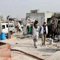 Gaza Blockade: Mitarbeitende laufen zwischen zerstörten Gebäuden