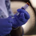 Masernimpfung wird aus Ampulle von Mitarbeiter entnommen.
