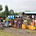 Die Bewohner*innen der Geflüchtetenunterkunft warten darauf, ihre Kanister mit Trinkwasser zu füllen 