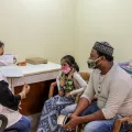 Eine Sozialarbeiterin von Ärzte ohne Grenzen im Gespräch zur Nachsorge mit einer Tuberkulose-Überlebenden und ihrem Vater. 