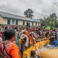 Viele Menschen, die aufgrund des Vulkanausbruchs in Goma flüchten mussten, stehen in einer Reihe, um sich Trinkwasser abzuholen. 