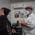 Eine Frau auf einer Krankenliege redet mit einem Arzt von Ärzte ohne Grenzen