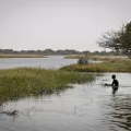 Mensch sitzt im Wasser am Ufer des Tschadsee