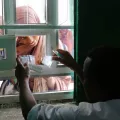 Eine Frau erhält ihre Medikamente durch ein Fenster.