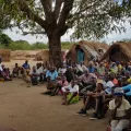 Unsere Mitarbeitenden sprechen mit Menschen in einem Vertriebenen-Camp.