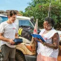 Zwei Mitarbeiter*innen kontollieren die Materialien für die mobile Klinik