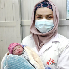 Gynäkologin Maryam mit einem Kind auf dem Arm