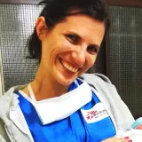 Lächelnde Frau hält Baby im Arm