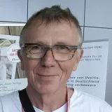 Ein Mann lehnt an einem unserer Fundraising-Stände und winkt.