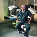 Ein Chirurg sitzt in einem OP-Saal